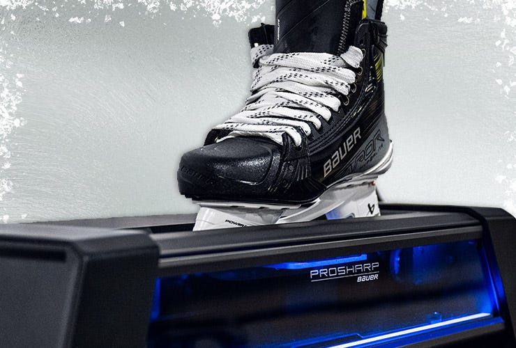 Hockey skate being sharpened by a PROSHARP Bauer AdvantEdge Home Machine on an icy background